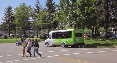 Pedestrians in a crosswalk with a SMART bus in background